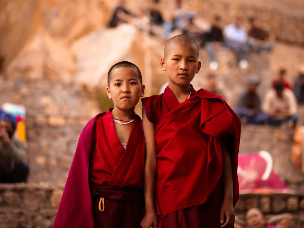 Two young Buddhist monks in red robes captured outdoors in HP, India.