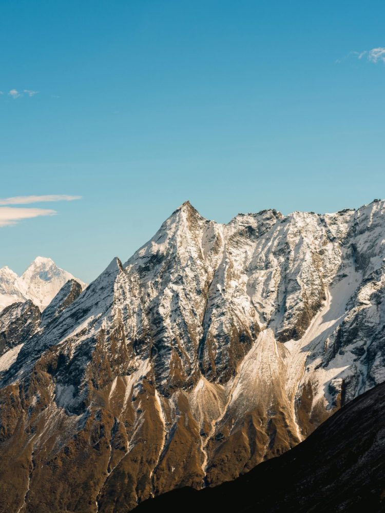 Stunning view of snow-capped Himalayan peaks against a clear blue sky in Nepal.